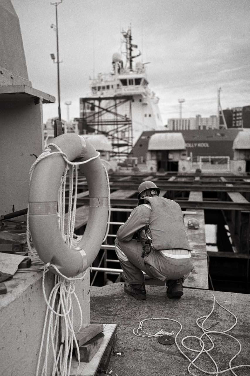 Worker reviewing waterfront dock and marine work area